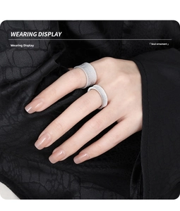 Detail showing brushed silver textured rings on hand with minimalist aesthetic