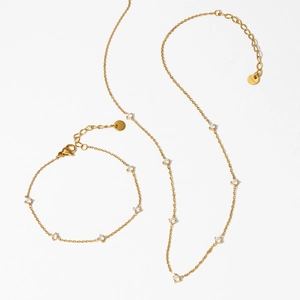 Elegant gold stainless steel jewelry set featuring zircon studded necklace and bracelet