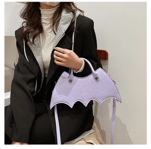 Detail showing purple bat-shaped bag with spiderweb texture and spider metal buckle