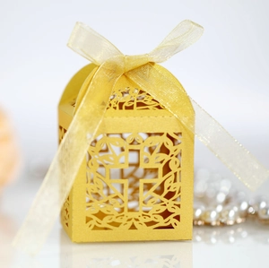 Detailed view of golden laser-cut gift box with hollow cross and yellow silk ribbon