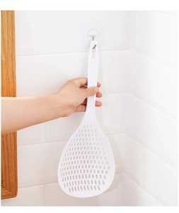 White plastic long-handle strainer spoon showing the convenient hanging storage design