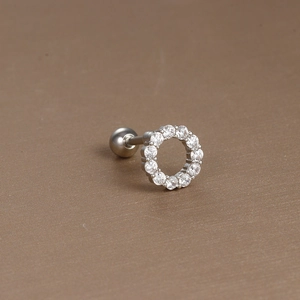 Macro detail of silver barbell earring with circular cubic zirconia pave and screw ball back