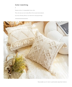 Detail of cream tufted bohemian cushion covers with tassels on a white fur rug