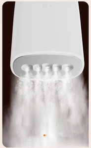 Detail view of the 5-hole steam nozzle on a portable white handheld garment steamer