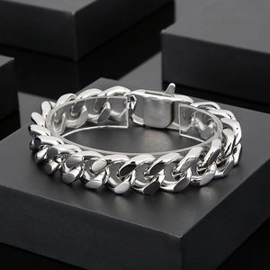 Detailed macro view of a silver Cuban link bracelet with a secure box clasp on a display