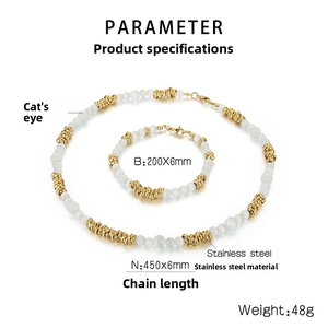 Détail des perles d'oeil de chat blanches et ornements dorés sur l'ensemble collier