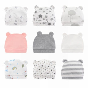 Set of 9 newborn cotton beanies in various patterns like stars and rainbow for infants