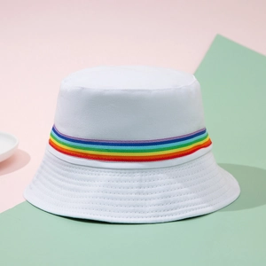 White cotton bucket hat with rainbow stripe ribbon trim on a pastel geometric background