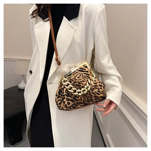 Leopard print crossbody shell bag with thick gold chain shown on a model for scale