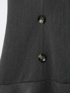 Détail du tissu sergé gris foncé et des boutons ambrés sur la robe à épaulettes