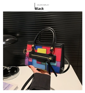 Close-up of geometric color block handbag with black leather strap and gold hardware