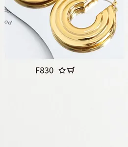 Macro shot of tiered golden hoop earrings with polished metal finish and industrial style