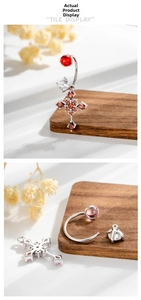 Detail von Silberkreuz-Piercing-Schmuck mit rotem birnenförmigem Stein und Gewinde