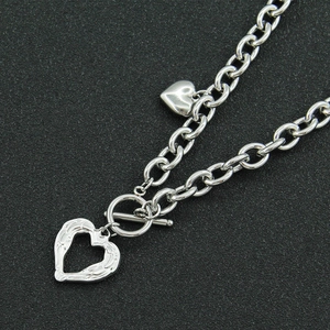 Silver stainless steel OT clasp necklace featuring hollow and solid heart-shaped pendants