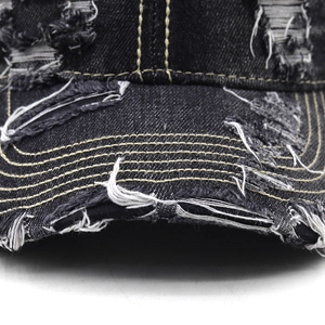 Detail of distressed dark grey denim baseball cap with yellow contrast stitching