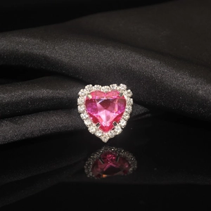 Close-up of pink heart-shaped crystal with white claw-set rhinestones on black silk