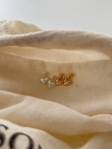 Close-up of gold and silver S925 sterling silver heart earrings with zircon inlay