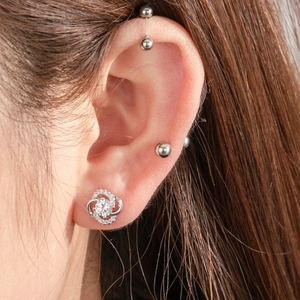 Elegant silver four-leaf clover stud earring with sparkling cubic zirconia on model ear