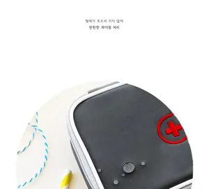 Detail of gray waterproof travel medical bag showing water droplets and red cross logo