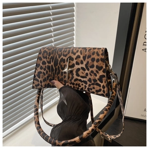 Détail macro d'un sac à bandoulière léopard avec une boucle en métal en forme d'étoile