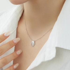 Gros plan du collier avec pendentif main de Hamsa en argent S925 et oxydes de zirconium