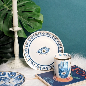 Ceramic plate and mug set featuring blue Hamsa Hand and Evil Eye gold patterns