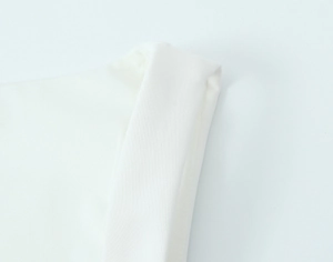 Close-up of high-quality white stretch fabric showing fine texture and neckline detail