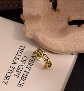 Gros plan détaillé d'une bague croisée en or vintage avec gravures florales sur fond rétro