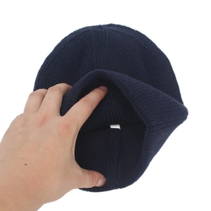 Thick navy blue knit beanie with vertical texture and stylish leather label detail