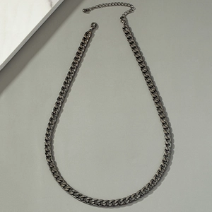 Detailed top view of a vintage dark grey metal Cuban link chain with lobster clasp