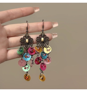 Detail view of retro bronze flower earrings with colorful round shell pendants