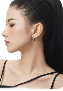 Polished S925 sterling silver crescent hoop earring worn by a model in a minimalist style