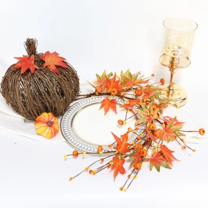 Close-up of autumn pumpkin decor with maple leaves and golden candle holder