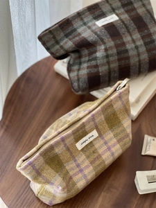 Detail of vintage plaid wool makeup bags with zipper closure and woven cotton label
