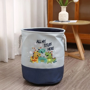 Detail of blue canvas storage basket featuring dinosaur embroidery and rope handles