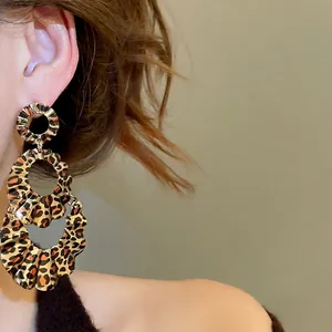 Three-tier leopard print ruffled hoop earrings on model with high gloss finish