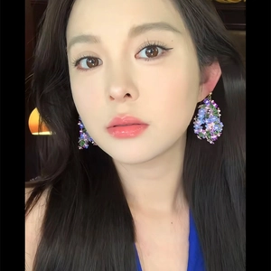 Gros plan de boucles d'oreilles en raphia floral avec perles sur un modèle féminin