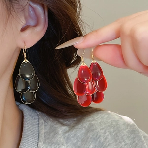 Detailed close-up of tiered water drop earrings with vibrant red and black enamel finish
