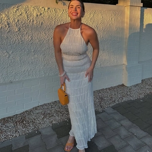 Detail of white pleated halter maxi dress showing fine fabric texture and backless design