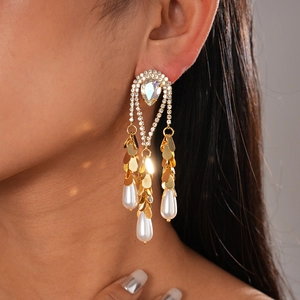 Détail de boucles d'oreilles frangées plaquées or 18 carats avec perles et cristaux
