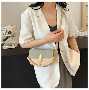 Detail of beige and gray saddle bag showing golden metal clasp and chain strap