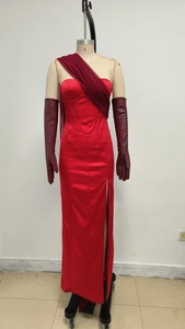 Detail of red satin evening gown with side slit and matching leather gloves on mannequin