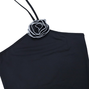 Détail de la fleur 3D avec bordure argentée sur ce haut dos nu noir pour femme