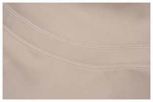 Detail of high-quality beige flared yoga pants showing precise double-stitch seams and fabric
