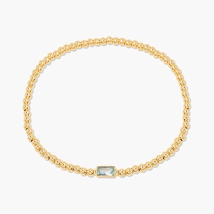 Bracelet minimaliste en perles dorées avec une pierre de naissance bleu clair rectangulaire