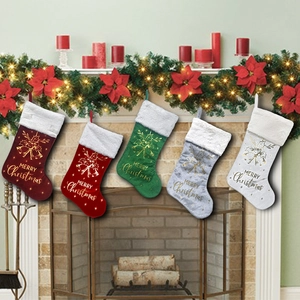 Five assorted Christmas stockings with gold Merry Christmas text hanging on a fireplace mantel