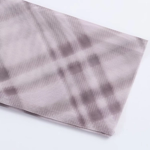 Macro view of plaid mesh fabric detail with purple tie-dye gradient texture