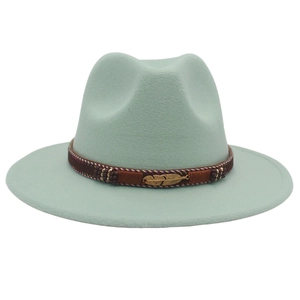 Detail of mint green wool felt fedora featuring a brown band and gold feather charm