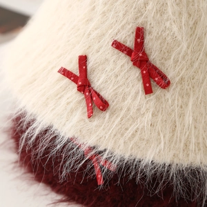 Primer plano de un sombrero de peluche suave con lazos rojos de lunares blancos