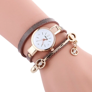 Fashionable wrap-around ladies watch with brown strap and gold case on model wrist